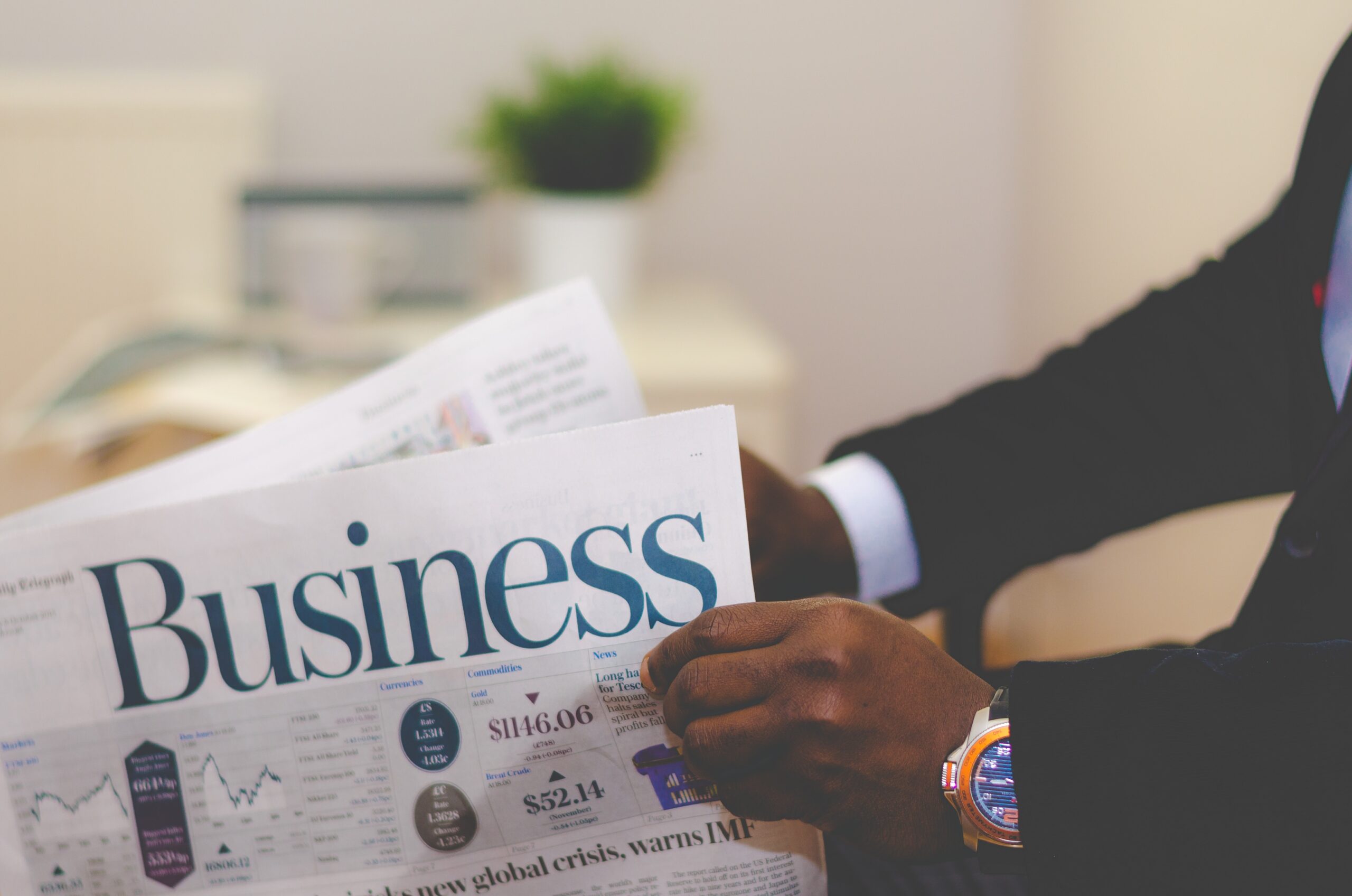 person wearing suit reading business newspaper about call center services for your small business