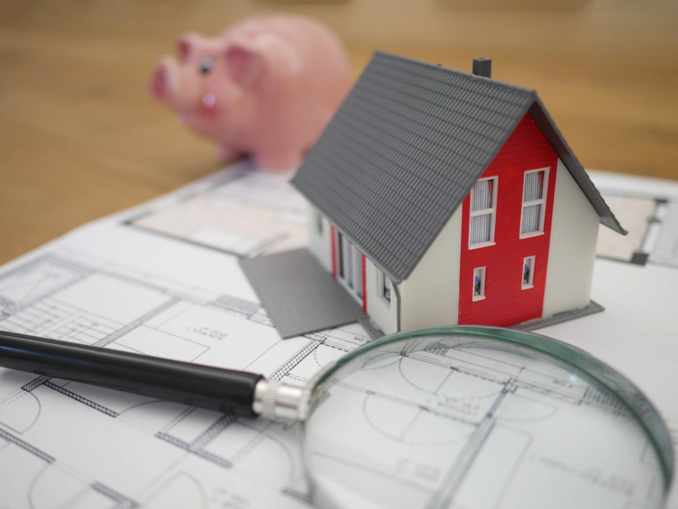 image of a model house and piggy bank representing a real estate firm and utilizing a real estate answering service
